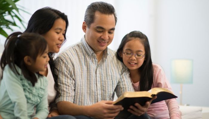 FamÃ­lia reunida lendo a BÃ­blia (Foto: Canva Pro)